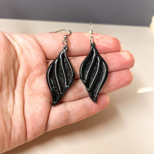 Boucles d’oreilles forme libre en acrylique noir et tissu noir pailleté – "Je suis là"